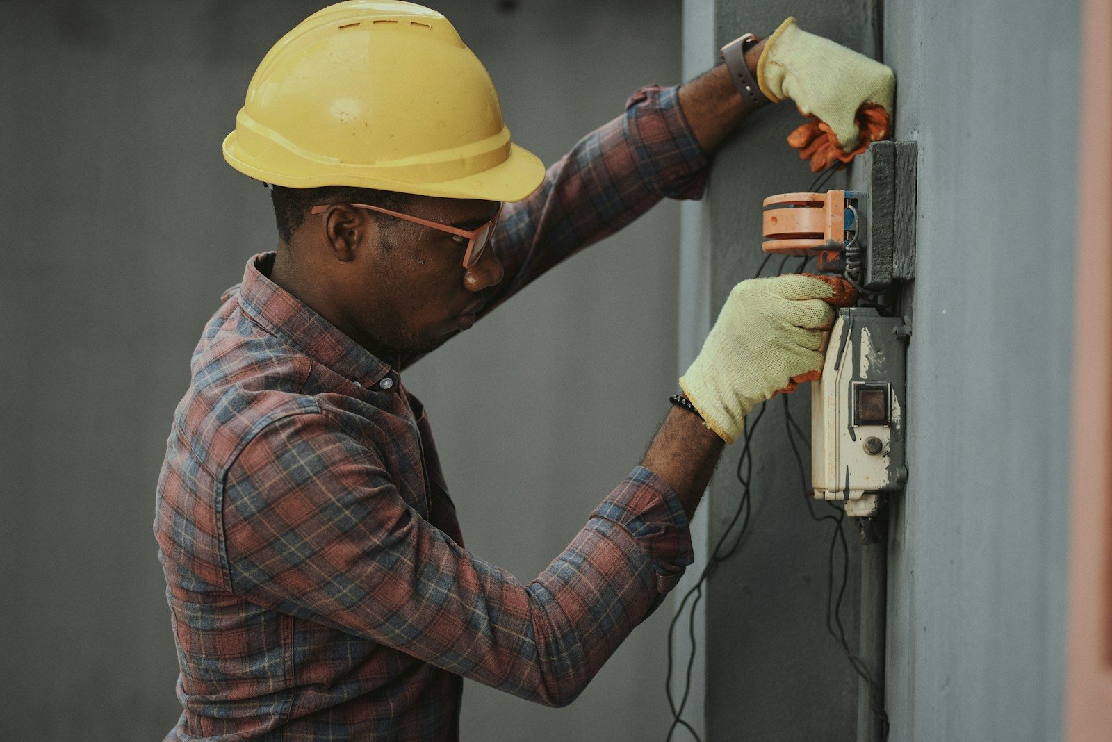An electrician focused on repair work — too busy to catch the phone.